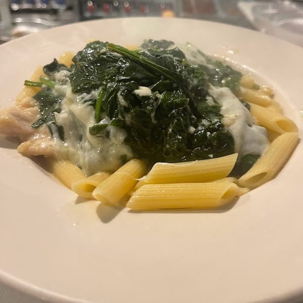 Penne pasta with chicken and creamy spinach sauce, a Soprano's Pizzeria & Restaurant dish.