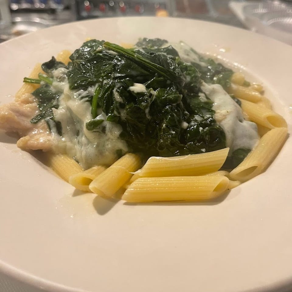 Penne pasta with chicken and creamy spinach sauce, a Soprano's Pizzeria & Restaurant dish.